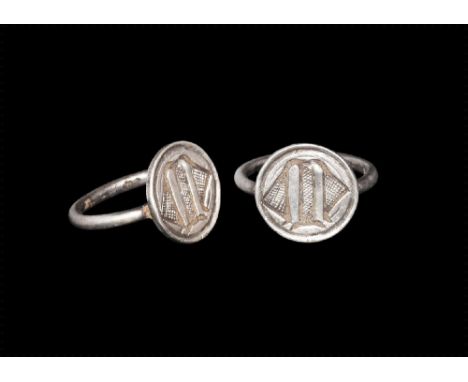 14th-15th century AD. A round section silver hoop supporting a circular bezel with deeply engraved Gothic capital 'M' at cent