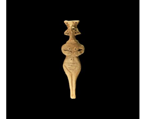 1180-700 BC. A buff coloured ceramic figure of a nude female, hands to the breasts, schematic face with pinched nose and appl