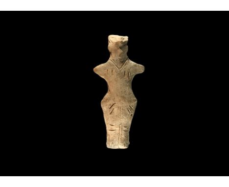 Neolithic, 6th-4th millennium BC. A ceramic figurine of a standing female with triangular face, arms extended, incised detail
