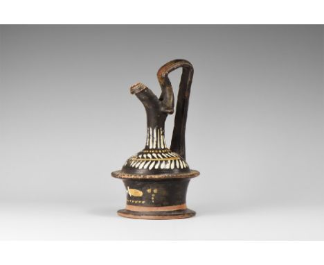 5th-4th century BC.
A ceramic blackware epichyses with cotton-reel body, domed shoulder and slender neck with C-section spout
