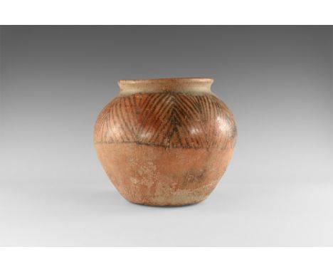 1st millennium BC. A red-glazed ceramic jar with low rolled rim, band of black-painted geometric ornament to the shoulder. 1.