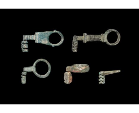 2nd-4th century AD. A mixed group of bronze keys comprising: three with cranked wards attached to a broad ring, upright teeth