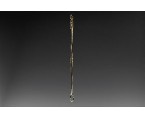 6th-7th century AD. A round-section bronze rod with hoop finial to one end, central baluster with ring-and-dot detailing to f