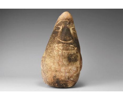 4th century BC. A rhyolite funerary idol with conical head and body, low-relief facial features and ribbed headdress; traces 