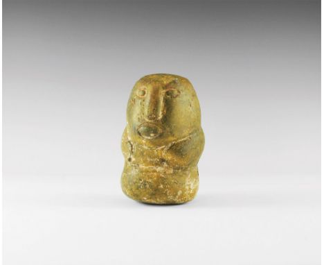 4th century BC. An oval polished stone with carved face features and hands to the both sides. 3.5 kg, 16cm (6 1/4"). Property