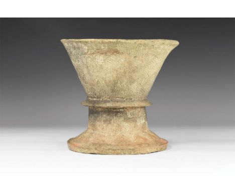 1st millennium BC. An unglazed ceramic vessel formed as a conical bowl with flared base and raised median collar, panels of i