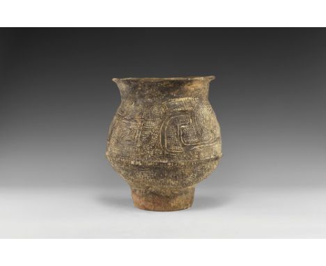 1st millennium BC. An unglazed ceramic vessel with squat body, tubular base, beaded collar to the equator, flared rim, impres