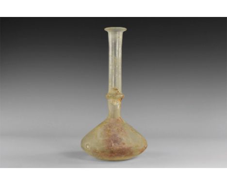 12th-14th century AD. A glass flask with biconvex body, dimple base, tall tubular neck with collar and flared rim, three radi