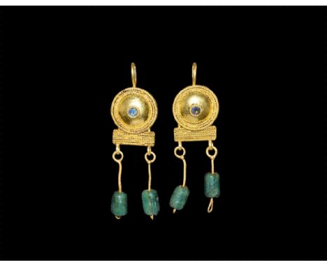 3rd century AD.
A matched pair of gold earrings, each a domed plaque with beaded wire border, filigree bands, central beaded 