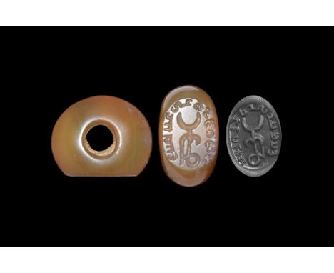 3rd-6th century AD. A carved agate plano-convex seal with a geometric symbol to the centre encircled by a text in Pahlavi scr