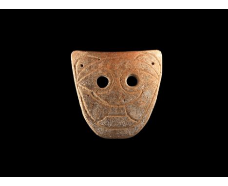 4th-3rd century BC. A D-shaped ceramic mask with two eye-holes and incised stylised facial details; pierced at the upper corn