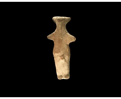 Neolithic, 6th-4th millennium BC. A ceramic figurine of a standing male with horned headdress, arms extended incised detail t