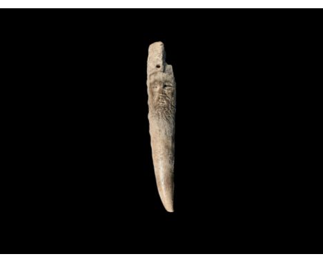 12th-15th century AD. A tapering piece of bone with a carved male face with beard and horned headdress. 16.87 grams, 11.5cm (