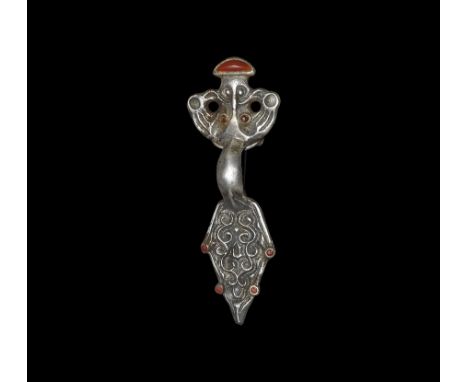 6th century AD.
A silver bow-brooch with headplate formed as a facing mask between opposed bird-heads, D-shaped cell above wi