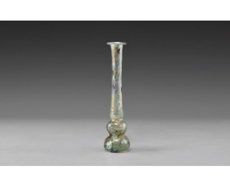 2nd-3rd century AD. A slender tubular unguentarium with rolled rim and two tiered finial bulbs. 25.05 grams, 13cm (5 1/4"). F