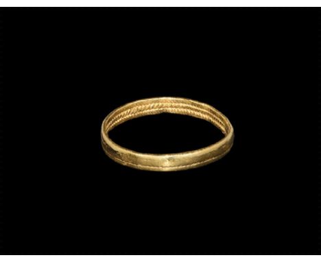 7th-10th century AD. A gold ring composed of three strands of soldered twisted gold wire forming a zip effect. 1.41 grams, 19