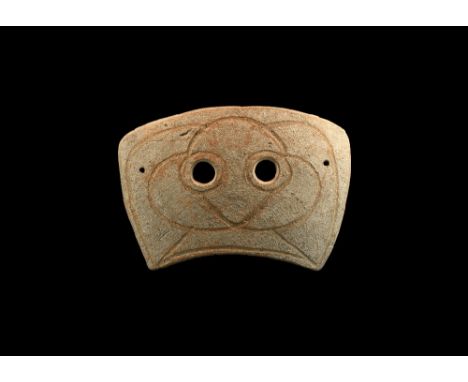 4th-3rd century BC. A rectangular slightly curved ceramic mask with two eye-holes and incised stylised facial details; pierce