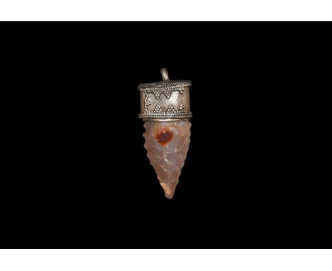 8th-12th century AD. A silver Elfshot amulet with filigree cap decorated with rows of triangles securing a Neolithic flint ar
