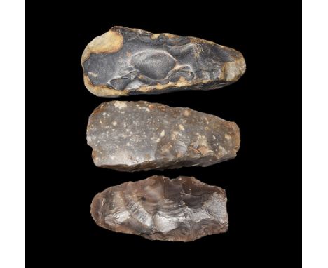 Neolithic, 4th millennium BC. A group of three flint axe heads, flat butted and with curving blade ends. 9.4 grams total, 80-