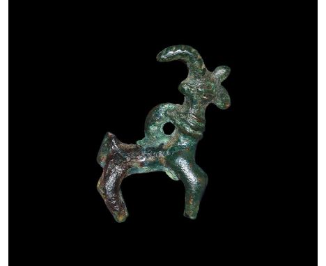 Late 2nd millennium BC. A bronze figurine of an ibex with curved horns, ribbed collar and loop to the rear. 16 grams, 41mm (1