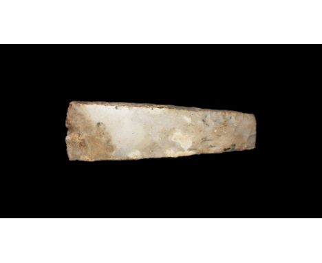 Neolithic, 4th-2nd millennium BC. A ground and polished stone handaxe with narrow square butt and broad curved and chamfered 