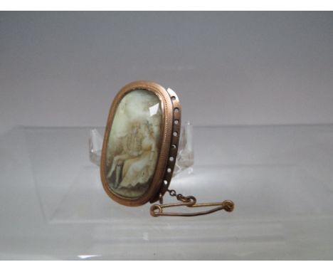AN ANTIQUE YELLOW METAL PORTRAIT BROOCH, the inset painted panel depicting a seated lady and gentleman in period clothing, ov