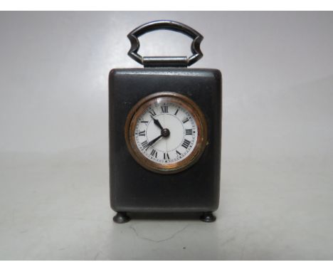 A FINE MINIATURE FRENCH TRAVEL CLOCK, housed in a polished steel case with carry handle, convex glass front, enamelled dial, 