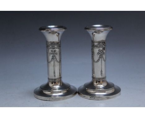 A PAIR OF HALLMARKED SILVER CANDLESTICKS - BIRMINGHAM 1905, with swag and bow decoration, filled bases, H 10 cm