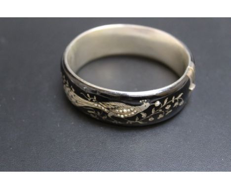 A BLACK ENAMEL STYLE BANGLE, decorated with a bird on a branch, having seed pearl detailing, Dia 6.75 cm