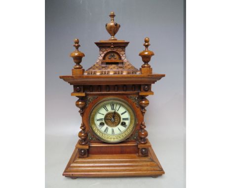 A GERMAN ARCHITECTURAL STYLE WOODEN CASED MANTEL CLOCK, with 8 day movement, striking on a single coil, with pendulum and key