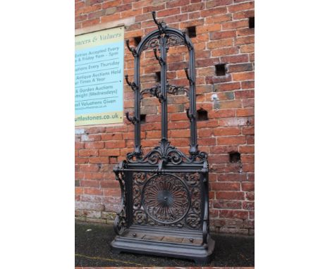 A DECORATIVE CAST IRON HALL STAND, the arched top above nine hooks, with a twin stick stand below and lift-out tray, H 184 cm