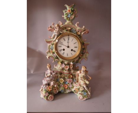 A LARGE CONTINENTAL PORCELAIN MANTEL CLOCK, the case adorned with two figures to the bottom with a cherub above, floral encru