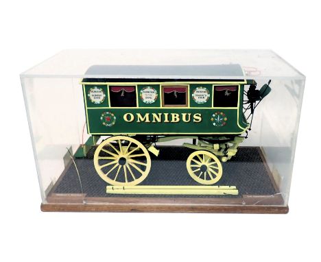 A scale model of a horse drawn omnibus coach, in black, green and yellow livery, 1cm:12cm, in perspex and wooden case, 54cm w