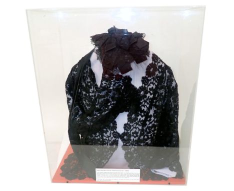 A black lace jacket, with hat, in perspex glazed case, 52cm wide. 