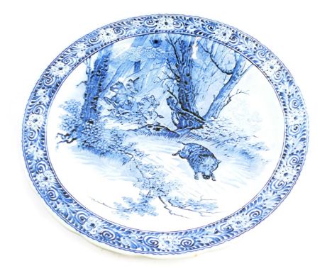 A Delft style charger, with transfer printed decoration of wart hog and hunting warriors, 39cm diameter. 