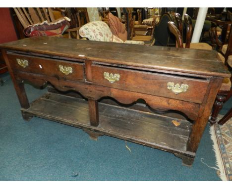 A George III oak dresser base, the rectangular top above two frieze drawers over shaped apron and on pot board base and brack