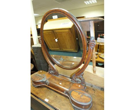 A Victorian mahogany toilet mirror the oval swing mirror above a curved lift top compartment flanked by two oval lift top jew