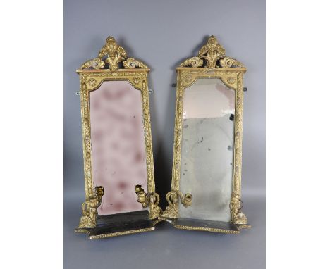 A pair of gilt gesso pier mirrors, 19th century, each with an open foliate scroll pediment above a rectangular plate within f