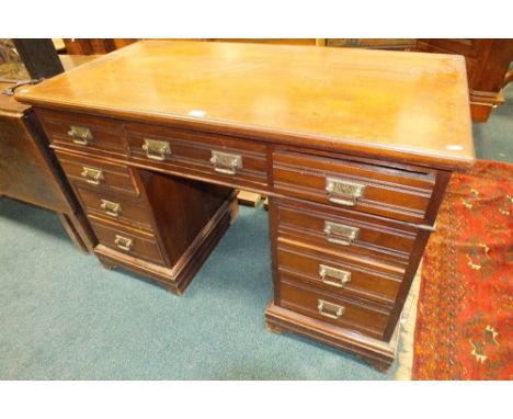 A Beaman of Manchester walnut pedestal desk with three grooved frieze drawers and six pedestal drawers with original handles 