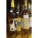 Seven assorted white wines, some label damage but appear to include Sauternes 1983