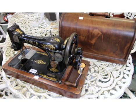 A vintage Singer Sewing machine in original wooden carry case