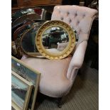 A 19th century button back armchair on turned front legs and original casters
