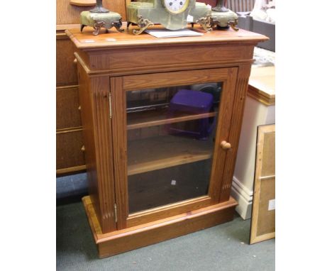 A pine book shelf with glazed door