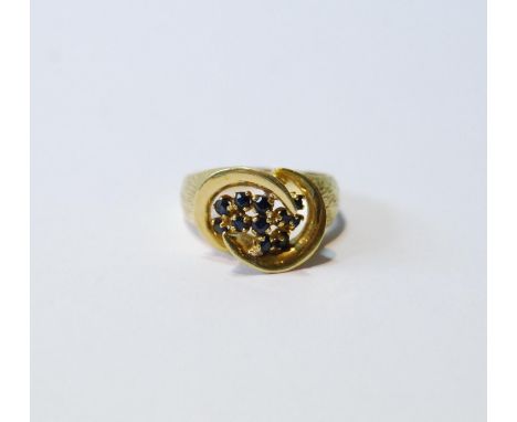 18ct gold ring with double spiral enclosing eleven sapphire collets, 1974, size M, 5g. 