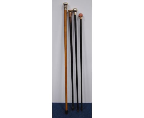 Four walking sticks to include three ebonised sticks with silver, rose-coloured&nbsp;quartz-style&nbsp;pommels, and a Malacca