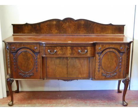 Irish-style mahogany sideboard with shaped pediment above a large drawer and cupboard door flanked by a cupboard door with mo