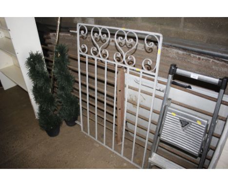 A grey painted metal garden gate