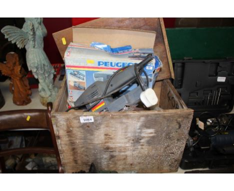 A box containing various tools to include a Peugeot orbital sander