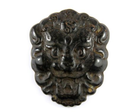 An early Chinese carved dark jade amulet of a lion head, H. 8cm.