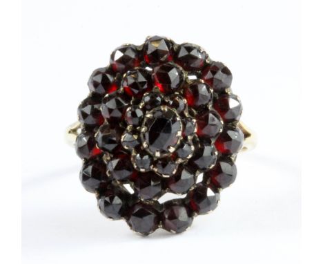 A yellow metal (tested 9ct gold) Bohemian garnet set cluster ring, (P).